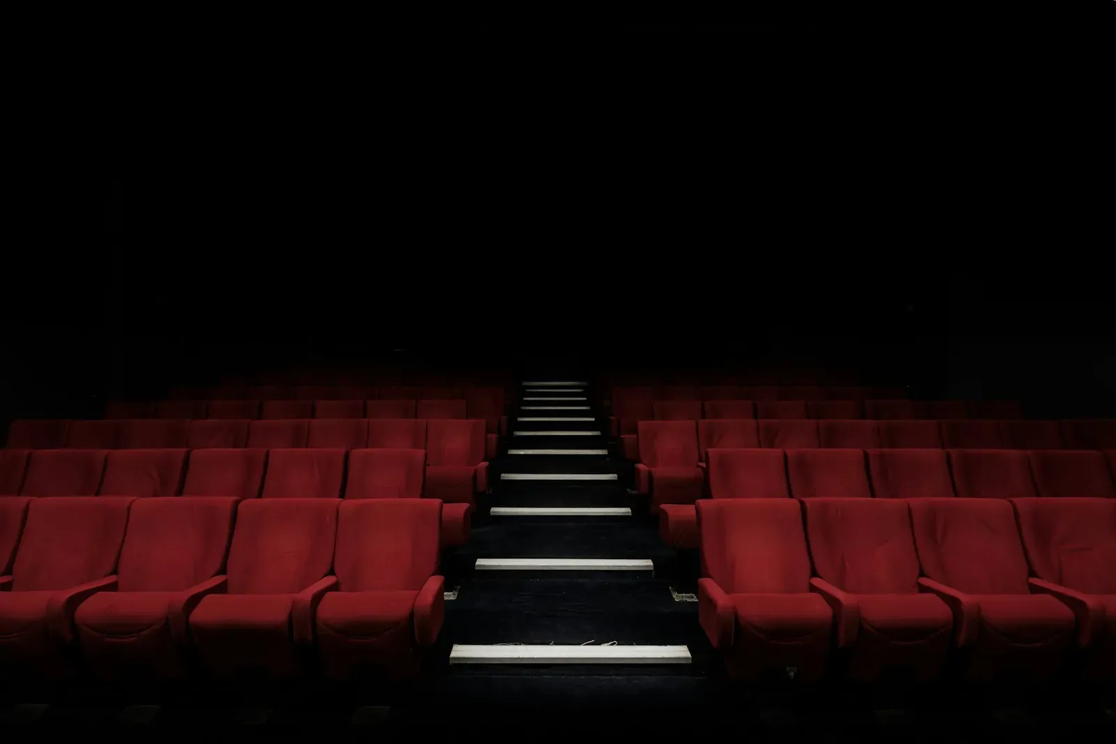 Poltronas vermelhas de uma sala de cinema vazia