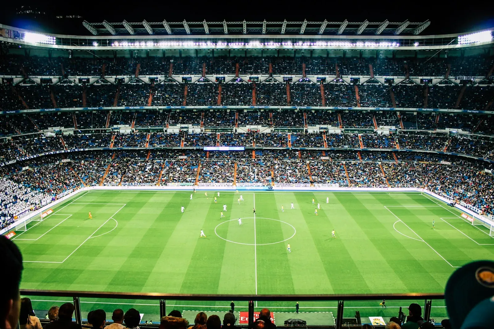 Estádio de futebol lotado durante uma partida à noite