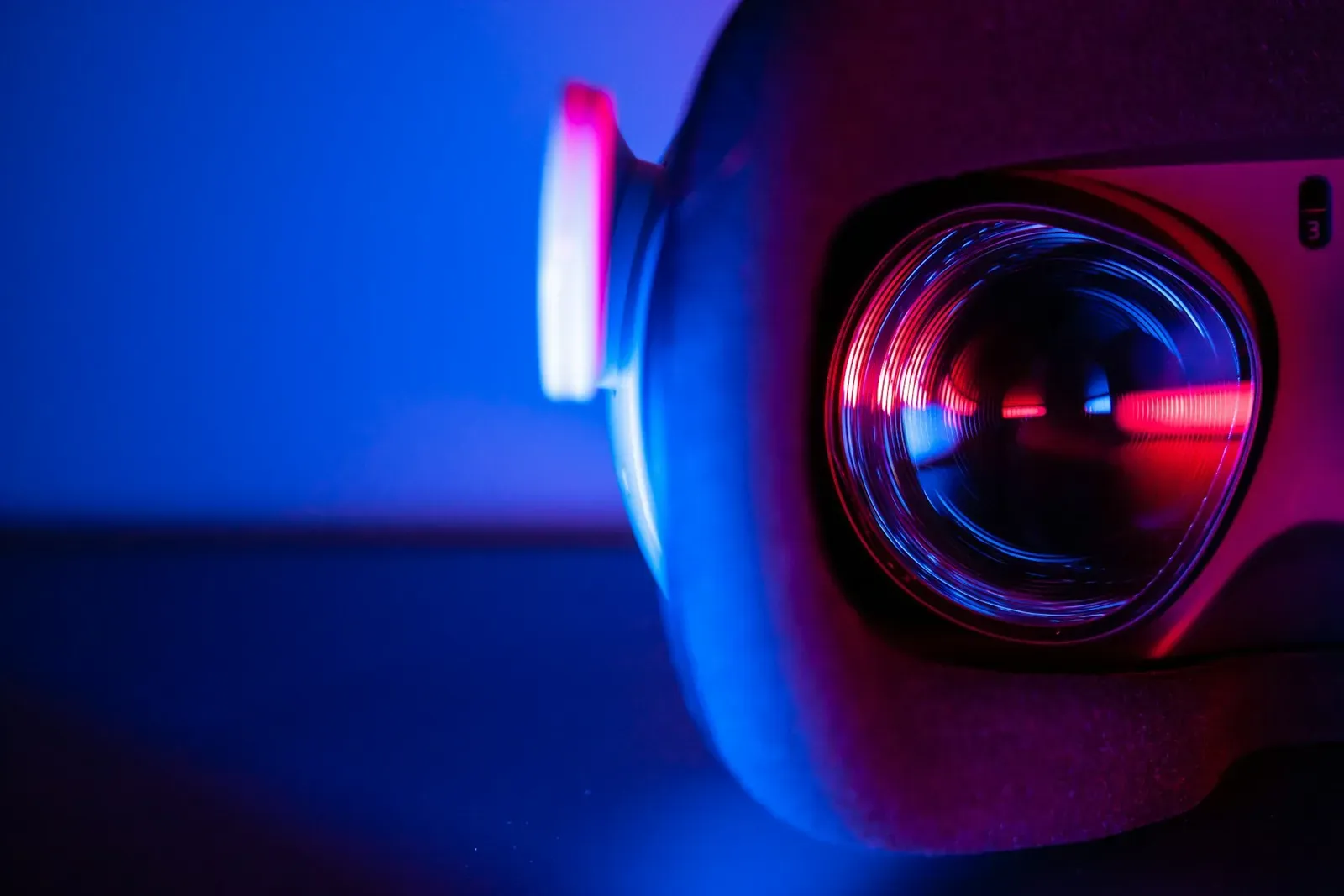Lente de projetor iluminada em tons de vermelho e azul